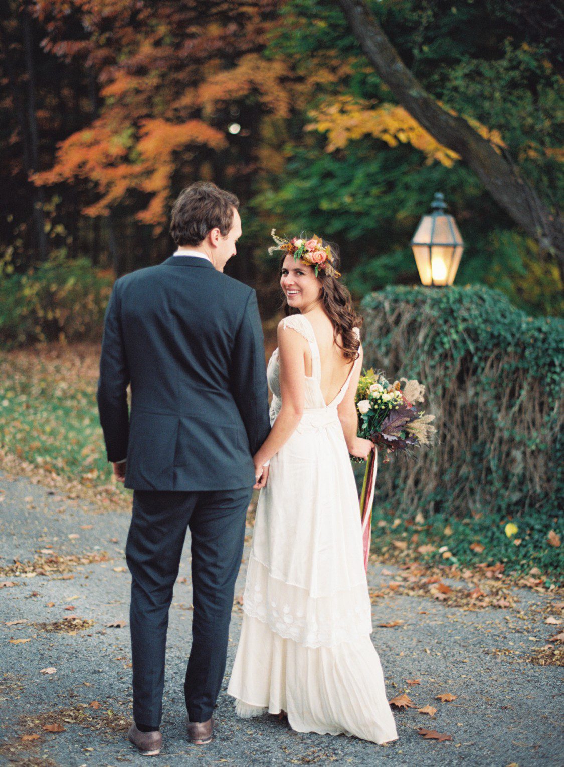 A couple pose for anniversary photos with ivy fence in background