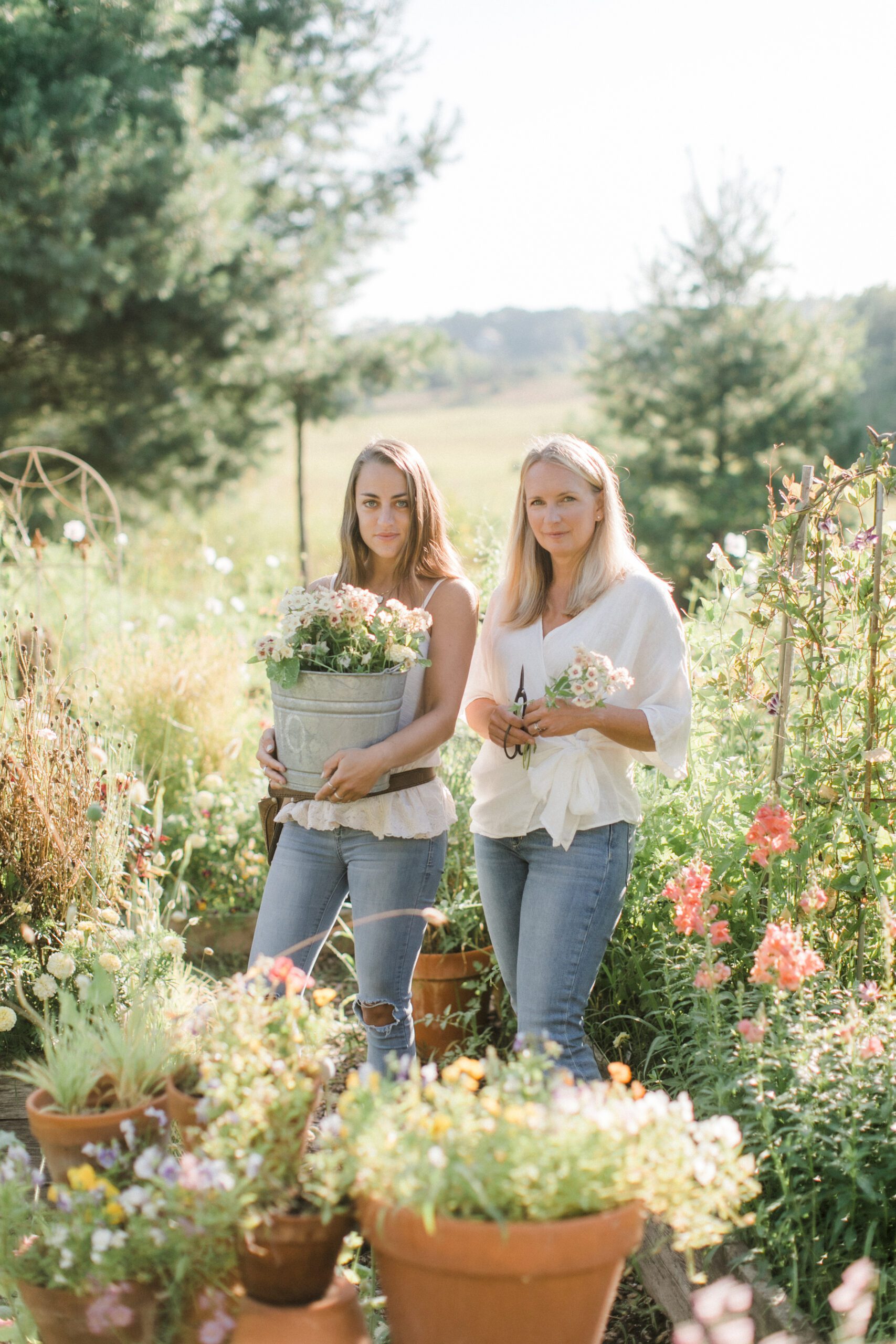 Two women pose in a garden for personal brand photography
