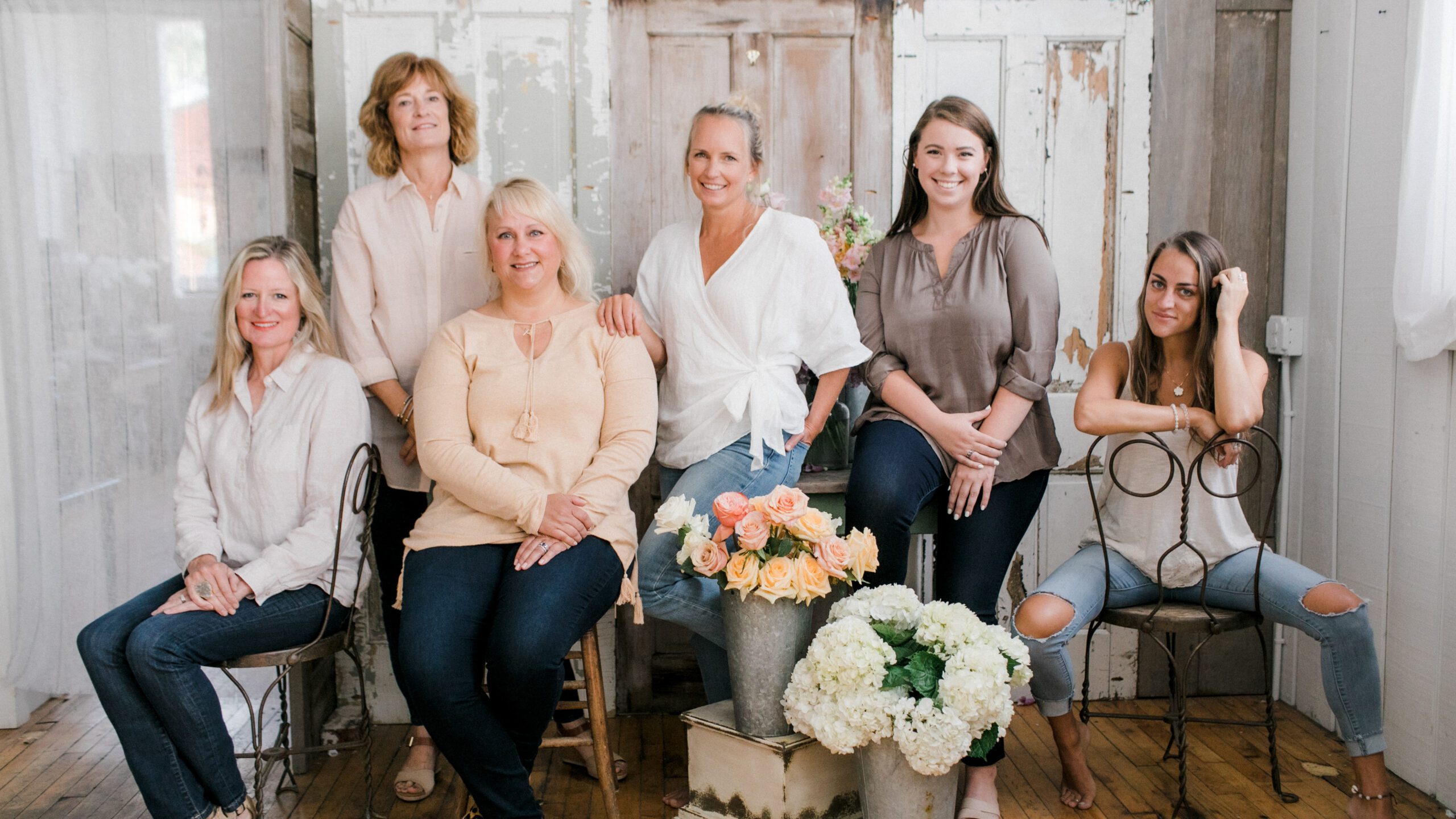 Six women pose in a group for business brand photography