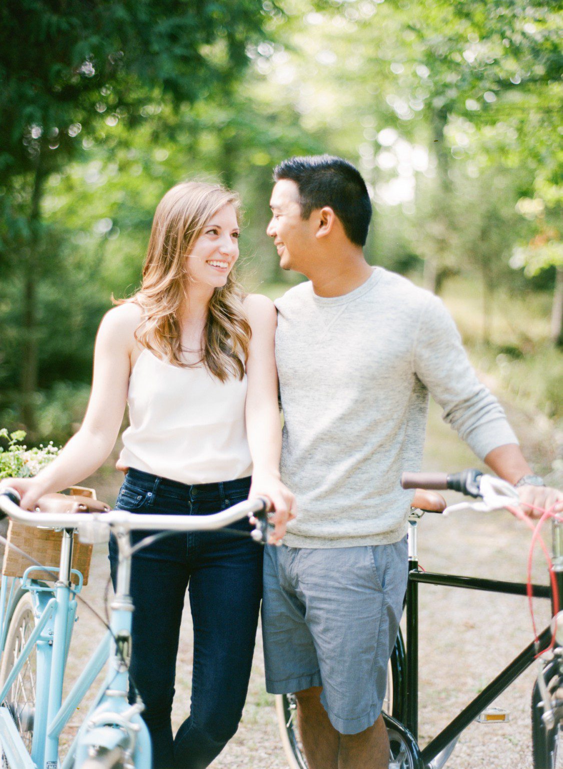 A northern michigan engagement photographer poses couple beside retro bikes