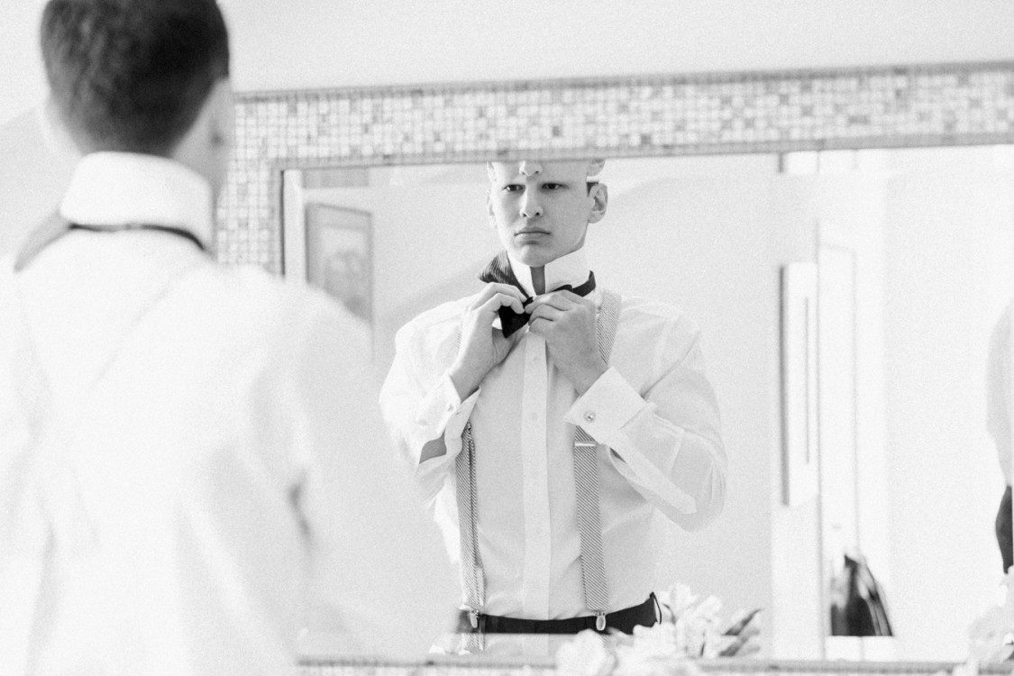 Handsome Groom gets ready while Petoskey wedding photographer documents