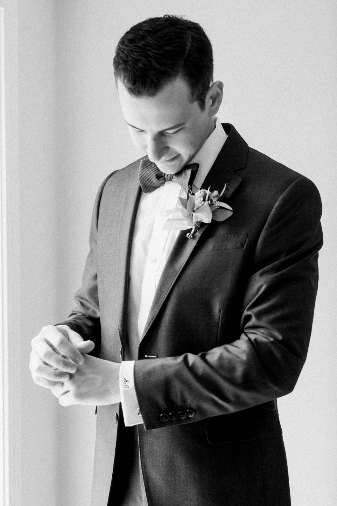 Groom gets ready for his wedding day while Petoskey wedding photographer photographs