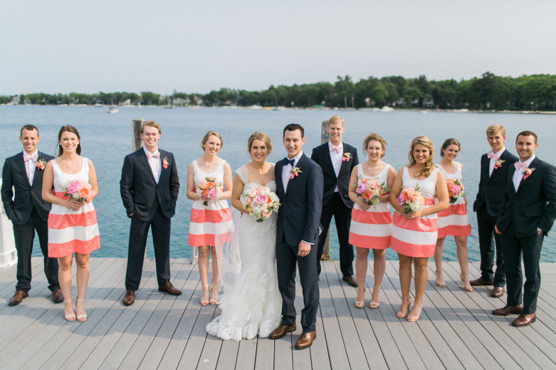 a bridal party poses beside a northern michigan dock