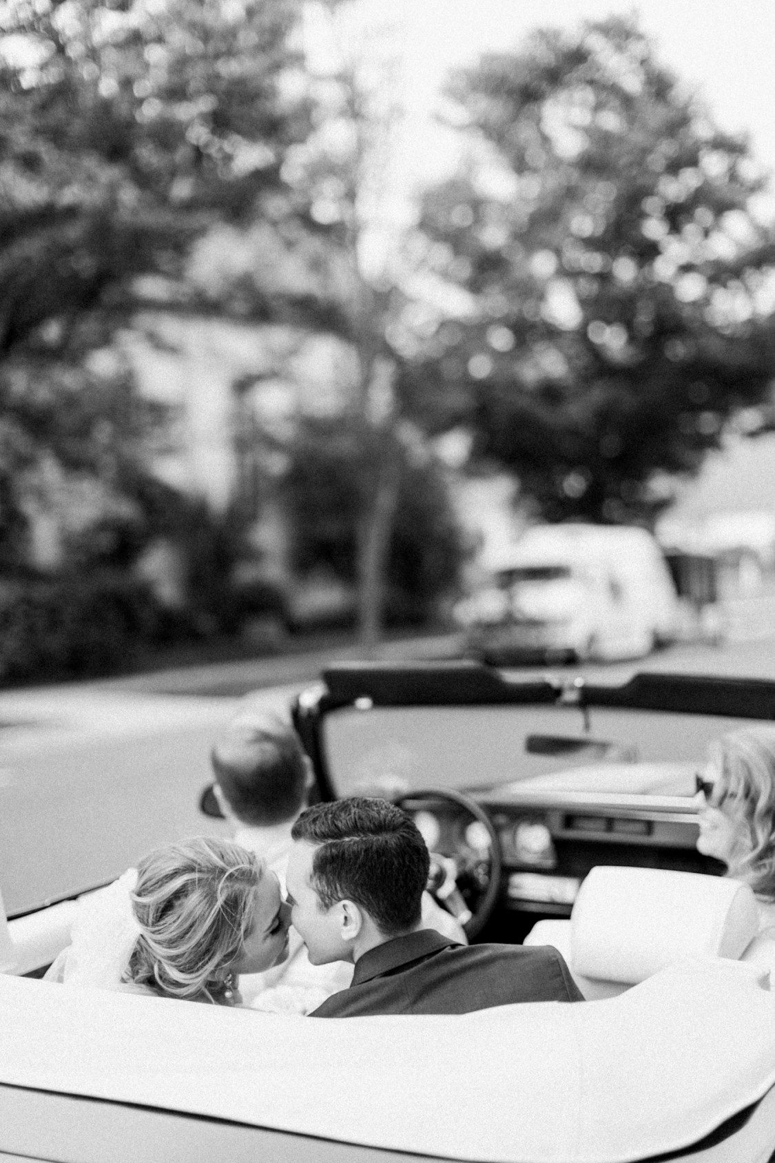 A bride and groom kiss in a classic Classic Car as shot by Petoskey wedding photographer
