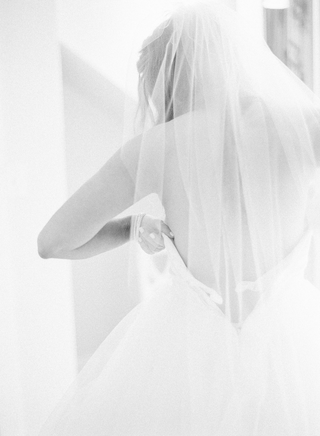 Photograph of a bride dressing in her gown for Arcadia michigan wedding photographer