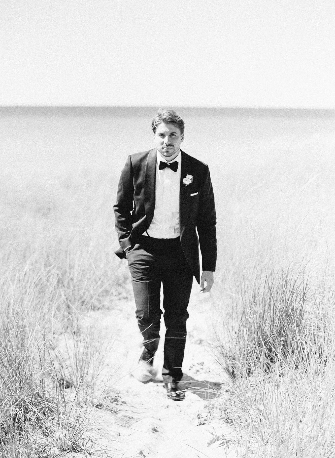 A groom walking towards an Arcadia Michigan Wedding photographer