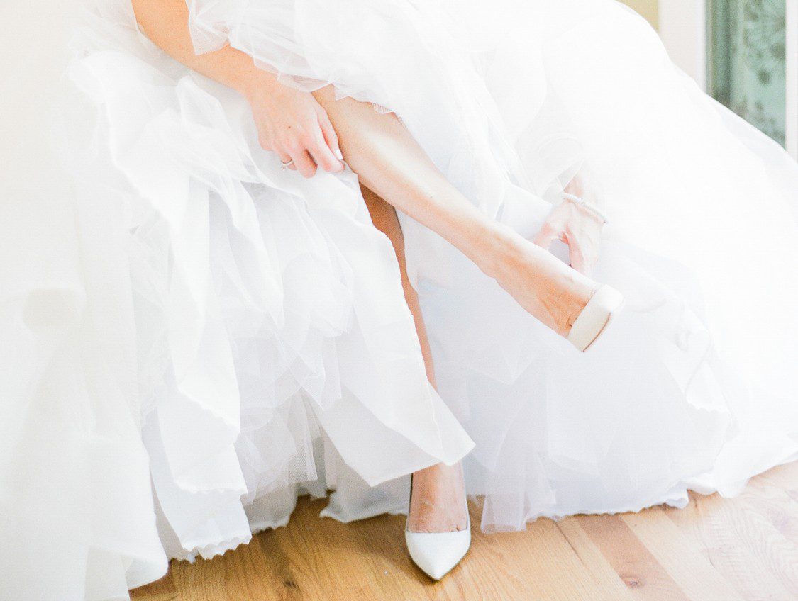A bride puts on her classic heel pointed shoes